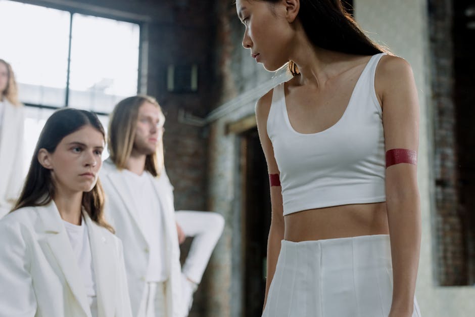 Stylish portrait of models in white, showcasing modern urban fashion in an industrial setting.